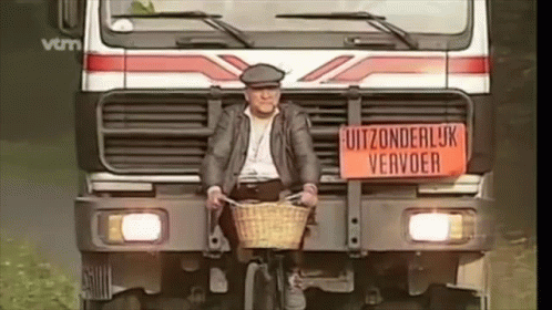 A Man Is Riding A Bike In Front Of A Truck With A Sign On It That Says Uitzonderlijk Vervoer GIF