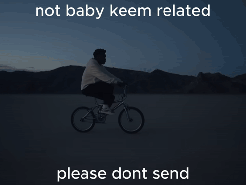 A Man Is Riding A Bike In The Dark With The Words Not Baby Keem Related Below Him GIF