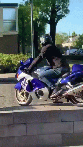 A Man Is Riding A Blue And White Motorcycle With Chinese Characters On The Front GIF