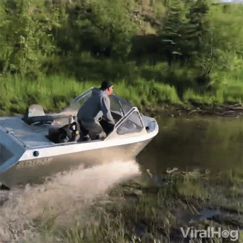 A Man Is Riding A Boat In A River With The Words Viralhog In The Corner GIF