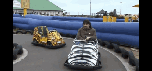 A Man Is Riding A Go Kart With A License Plate That Says ' Aa ' On It GIF