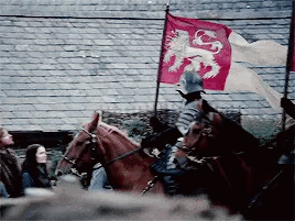A Man Is Riding A Horse With A Red Flag With A Lion On It . GIF