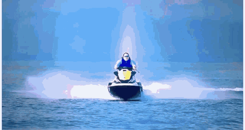 A Man Is Riding A Jet Ski In The Water GIF