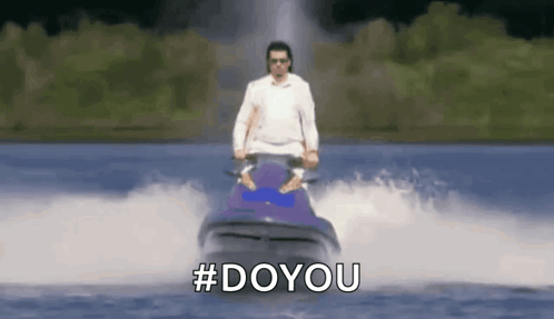 A Man Is Riding A Jet Ski In The Water With The Hashtag #Doyou . GIF