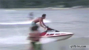 A Man Is Riding A Jet Ski On A Body Of Water GIF
