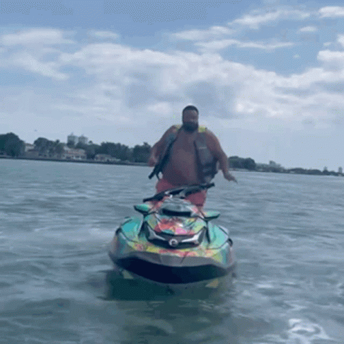 A Man Is Riding A Jet Ski On The Water GIF