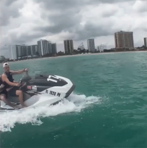 A Man Is Riding A Jet Ski With A License Plate That Says Fl 7028 Pm GIF