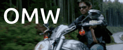 A Man Is Riding A Motorcycle On A Road With The Word Omw Written Above Him GIF