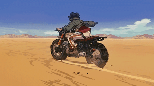 A Man Is Riding A Motorcycle Through The Desert GIF