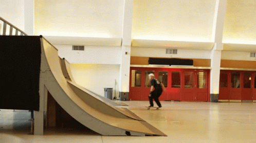 A Man Is Riding A Skateboard Down A Ramp GIF