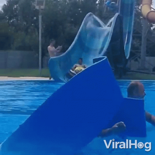 A Man Is Riding A Tube Down A Water Slide At A Water Park With The Words Viralhog On The Bottom GIF