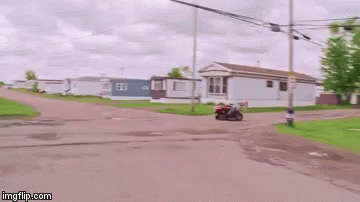 A Man Is Riding On The Back Of A Lawn Mower . GIF