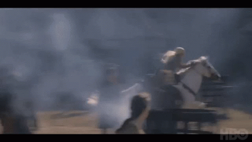 A Man Is Riding On The Back Of A White Horse In A Smokey Area . GIF