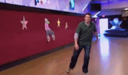 A Man Is Rollerblading In A Bowling Alley With Stars On The Wall GIF