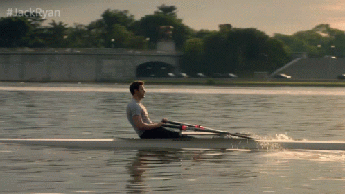 A Man Is Rowing A Boat On A Lake With #Jackryan Written Above Him GIF