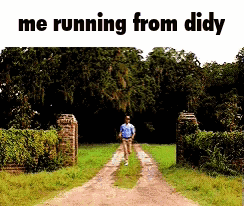 A Man Is Running Down A Dirt Road In A Field . GIF