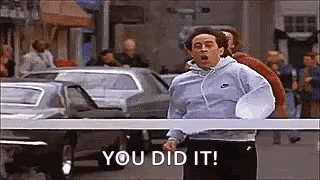 A Man Is Running Down A Street With The Words `` You Did It '' Written On The Screen . GIF