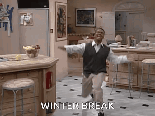 A Man Is Running In A Kitchen With The Words Winter Break Written On The Floor Behind Him . GIF