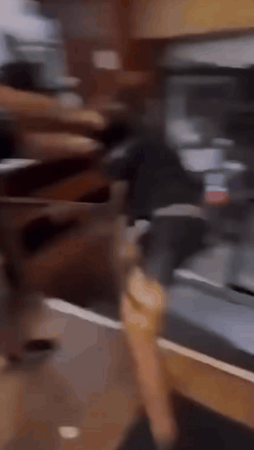 a man is running on a treadmill in front of a refrigerator while another man watches .
