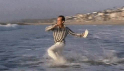 Man Running Out Of Ocean With Flying Kite GIF