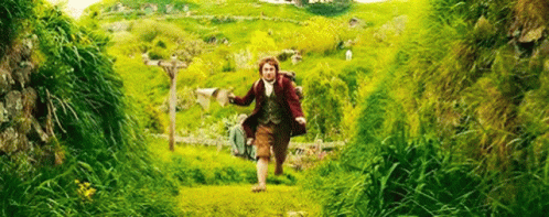 A Man Is Running Through A Grassy Field With A Backpack On His Back . GIF