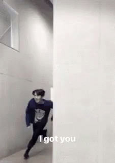 A Man Is Running Through A Hallway Next To A Wall And Says `` I Got You '' . GIF