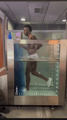 A Man Is Running Through A Machine That Says Core On It GIF