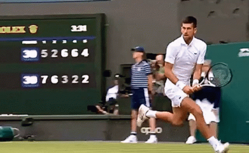 A Man Is Running With A Tennis Racket On A Tennis Court GIF