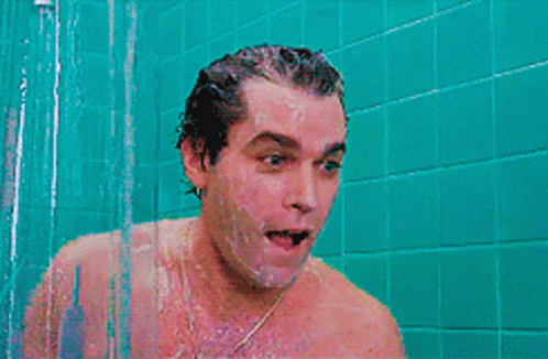 A Man Is Screaming In A Shower With A Blue Tiled Wall Behind Him GIF