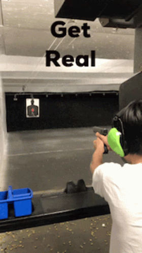 A Man Is Shooting A Gun In A Shooting Range With The Words Get Real Behind Him GIF