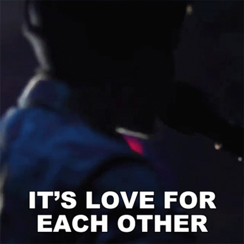 a man is singing into a microphone and the words it 's love for each other are visible