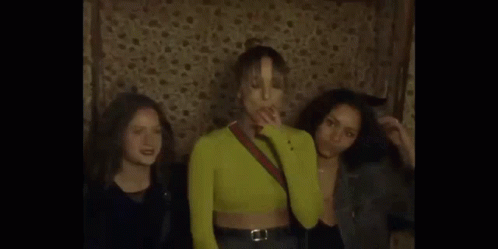 A Man Is Singing Into A Microphone In A Dark Room With Smoke Coming Out Of It . GIF