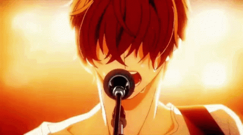 A Man Is Singing Into A Microphone While Playing A Guitar . GIF