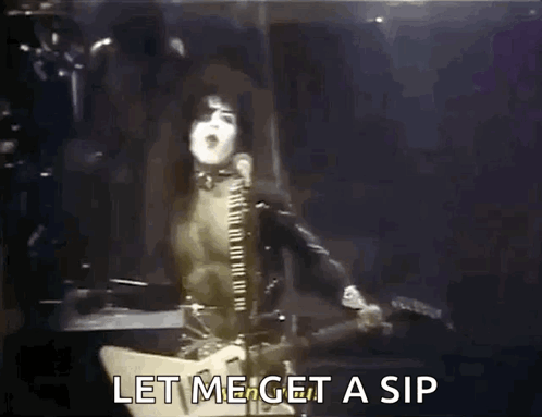 A Man Is Singing Into A Microphone While Playing A Guitar And Says Let Me Get A Sip GIF