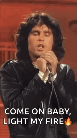 a man is singing into a microphone while wearing a leather jacket .