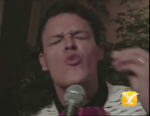 a man is singing into a microphone with a bird on it