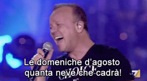 A Man Is Singing Into A Microphone With The Words Le Domeniche D' Agosto Quanta Neve Che-Cadra GIF