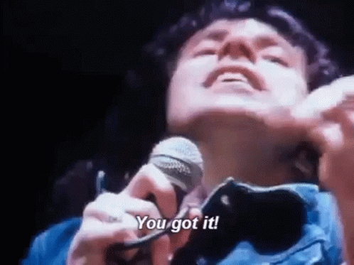 A Man Is Singing Into A Microphone With The Words `` You Got It '' . GIF