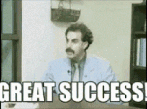 A Man Is Sitting At A Desk And Says Great Success GIF