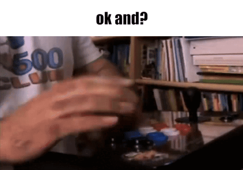 A Man Is Sitting At A Desk In Front Of A Bookshelf With The Words Ok And Written On The Bottom . GIF