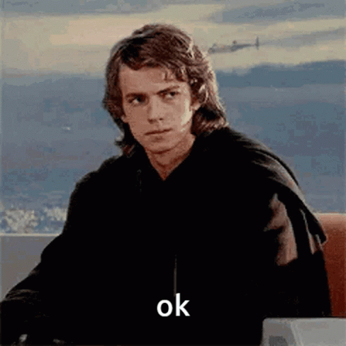 A Man Is Sitting At A Desk With A Plane In The Background And The Word Ok On The Screen . GIF