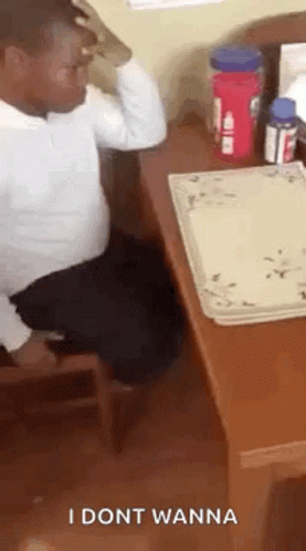 a man is sitting at a desk with a plate on it and a bottle of water .
