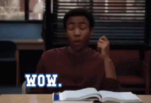 A Man Is Sitting At A Desk With His Eyes Closed And The Word Wow Written On The Screen GIF