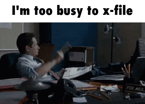 A Man Is Sitting At A Desk With His Feet Up And A Fox Mail Holder GIF