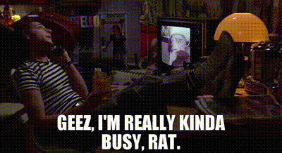 A Man Is Sitting At A Desk With His Feet Up And Talking On A Phone . GIF