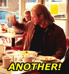 A Man Is Sitting At A Diner Table With Another Written On The Table GIF