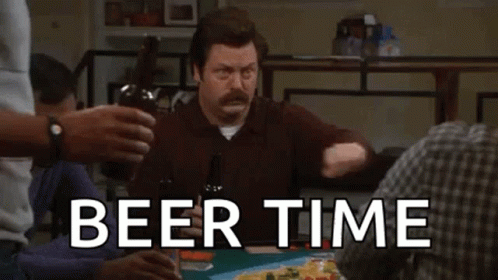 a man is sitting at a table holding a bottle of beer .