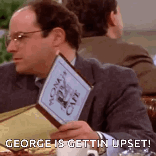 A Man Is Sitting At A Table Holding A Menu And Saying `` George Is Gettin Upset ! '' GIF