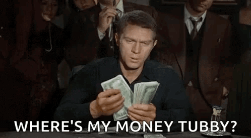 A Man Is Sitting At A Table Holding A Pile Of Money And Asking Where 'S My Money Tubby . GIF