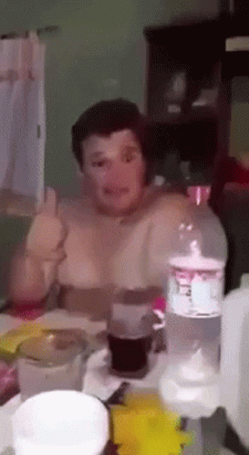 A Man Is Sitting At A Table With A Bottle Of Sprite On It GIF